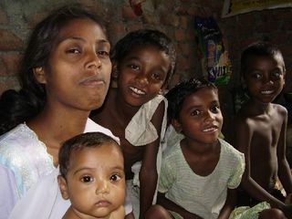 Basanti, shown here with children in her family, survived a witch hunt in India's tea plantations.