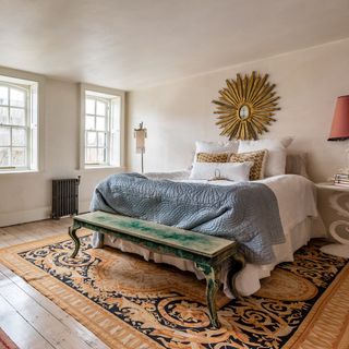 Neutral painted bedroom with wall artwork and oak flooring