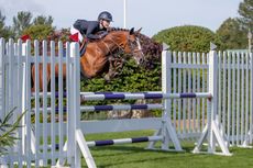 Lauren Wilkins jumps a fence on Eloclea Ro. Del Colle San Marco in the The Oakley Coachbuilders Bs Winter Grade Jc Championship at The Longines Royal International Horse Show, The All England Jumping Course, Hickstead