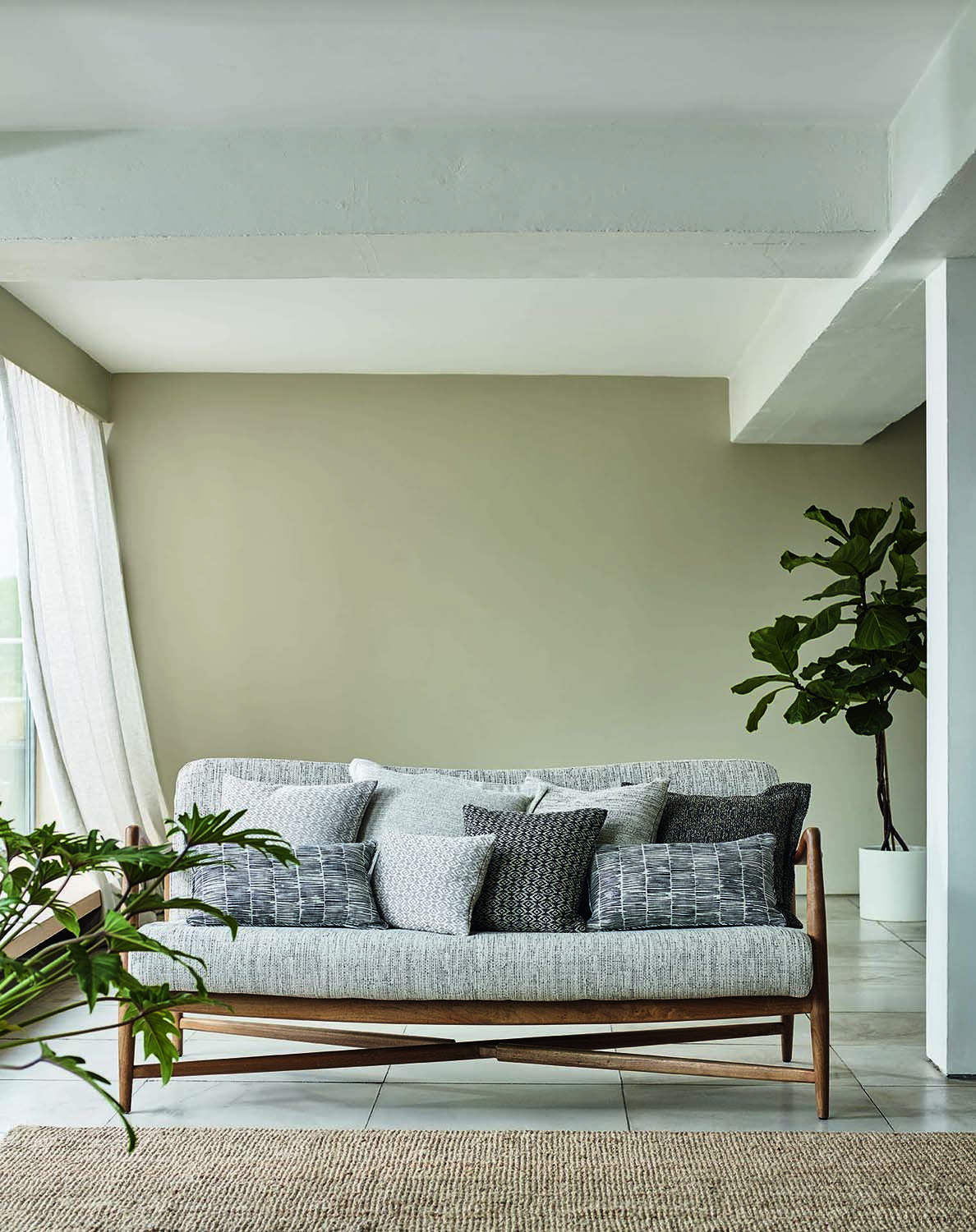 Beige living room with grey sofa and large houseplants