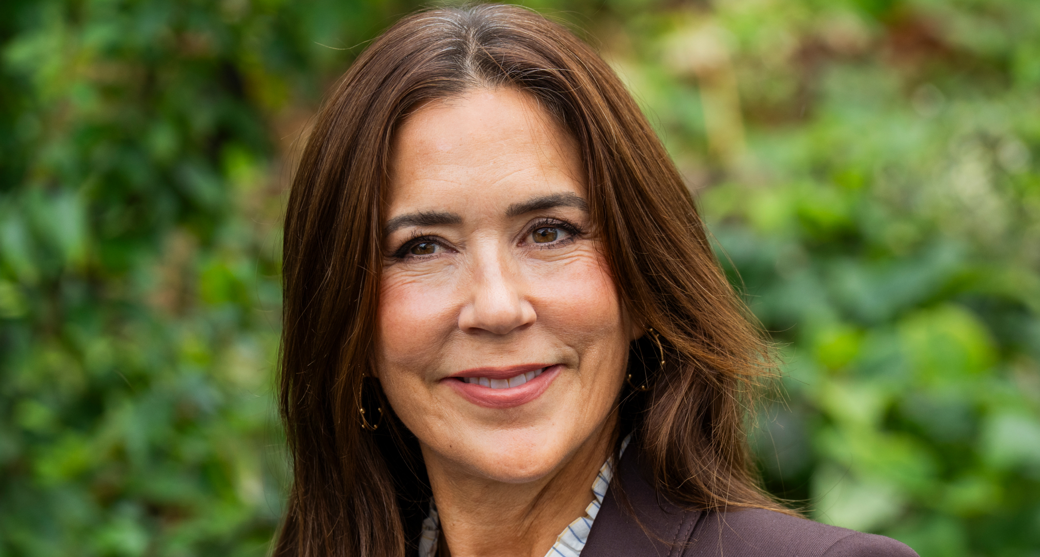 Queen Mary smiling in a brown blazer