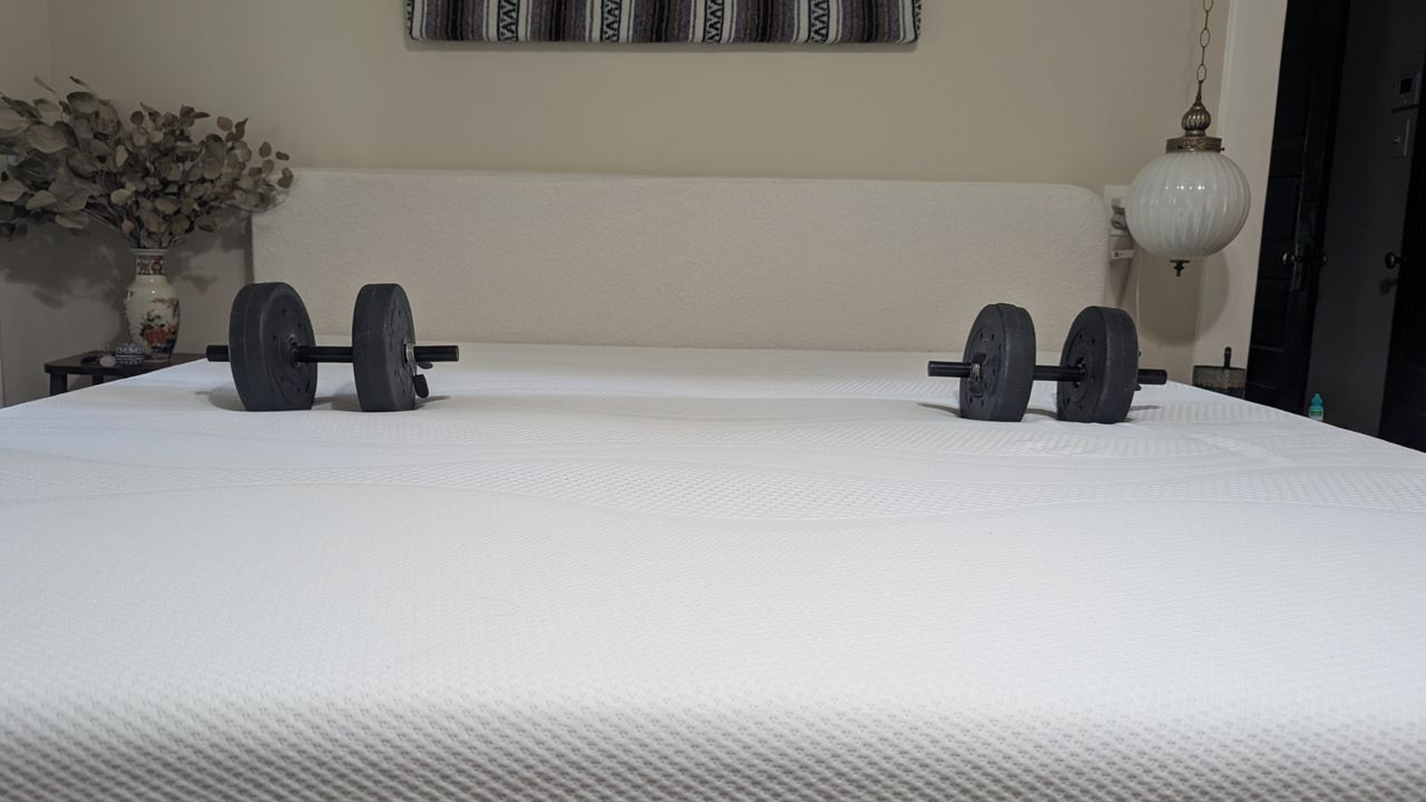 Dumbbells and wine glass placed on Sleep Number i8 smart mattress showing motion isolation