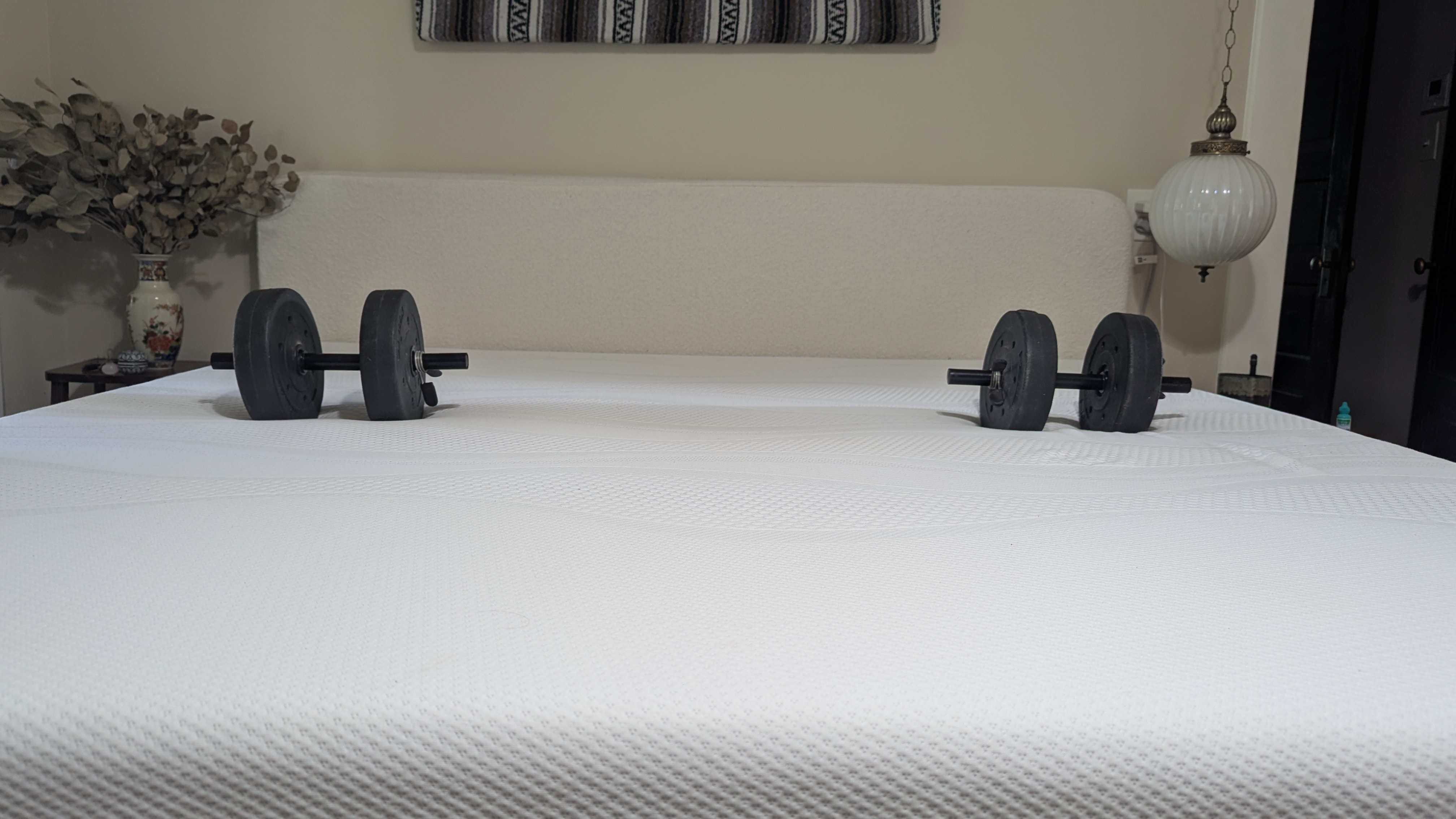 Dumbbells and wine glass placed on Sleep Number i8 smart mattress showing motion isolation