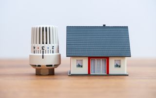 tiny model of house next to radiator valve