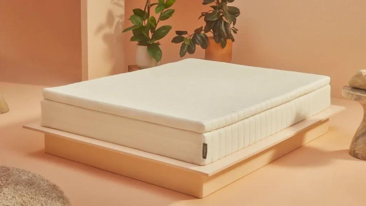 Earthfoam Mattress Topper on a mattress against peach-colored walls.