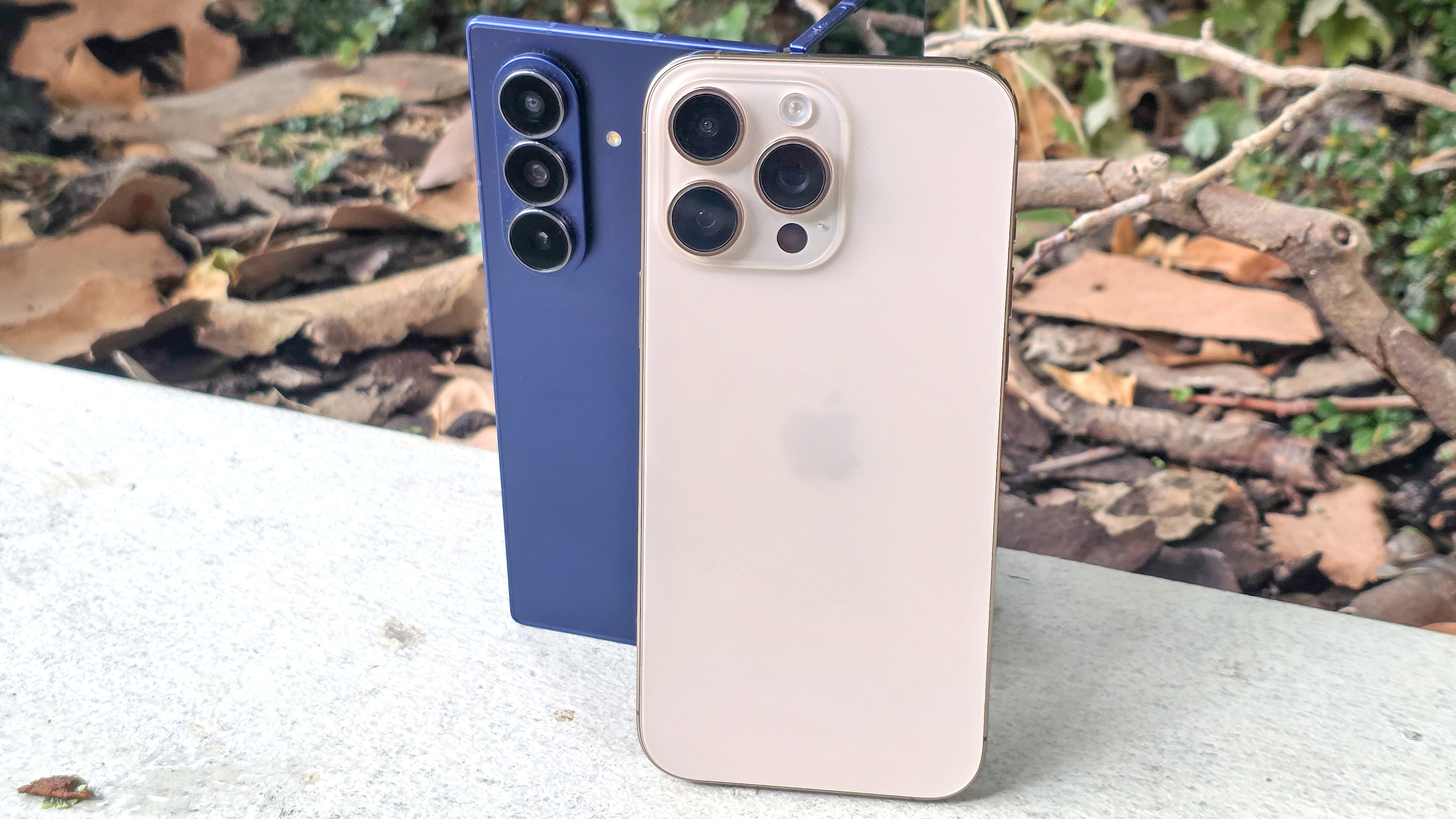 Samsung Galaxy Z Fold 7 and iPhone 16 Pro Max stood together on a wall