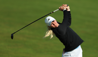 Annabell Fuller strikes a fairway wood and watches its flight