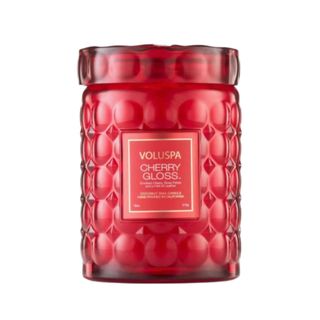 A red candle in a red glass jar
