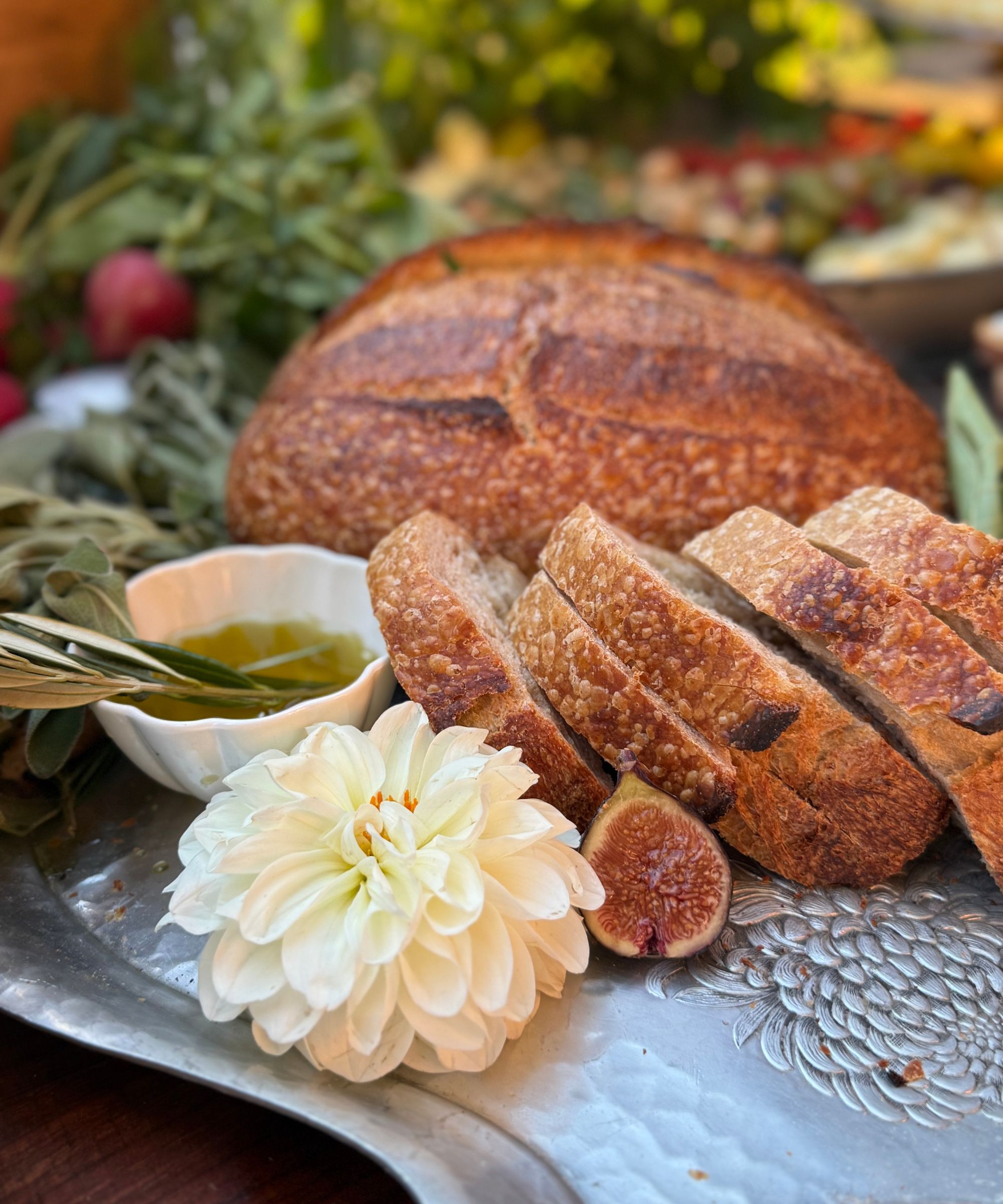 Sliced bread on a vintage tray with flowers figs and herb oil