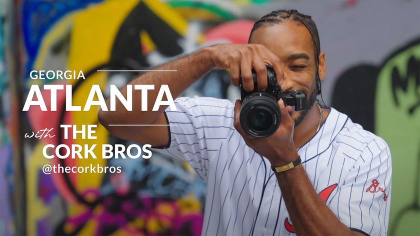 Michelangelo Corkrum taking a photo in front of a wall of graffiti next to the text “Georgia Atlanta with the Cork Bros” 