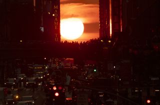 The sun sets along 42nd Street one night before the summer Manhattanhenge on July 11, 2023, in New York City.