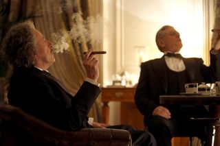 Albert Einstein (Geoffrey Rush) smokes a cigar with President Franklin Delano Roosevelt (Mitchell Mullen) in National Geographic's "Genius."