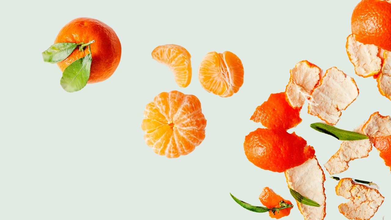 Oranges and orange peels on a sage green background