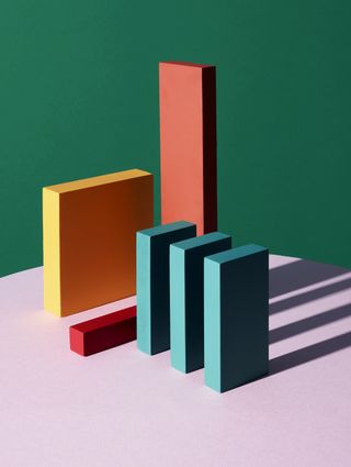 Bauhaus, by Mitch Payne. A painting of various sized and coloured 3D rectangles standing in a row with long shadows.