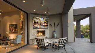 Full shade outdoor TV on wall with fireplace