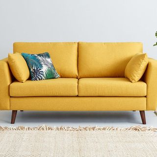 living room with white wall and yellow couch
