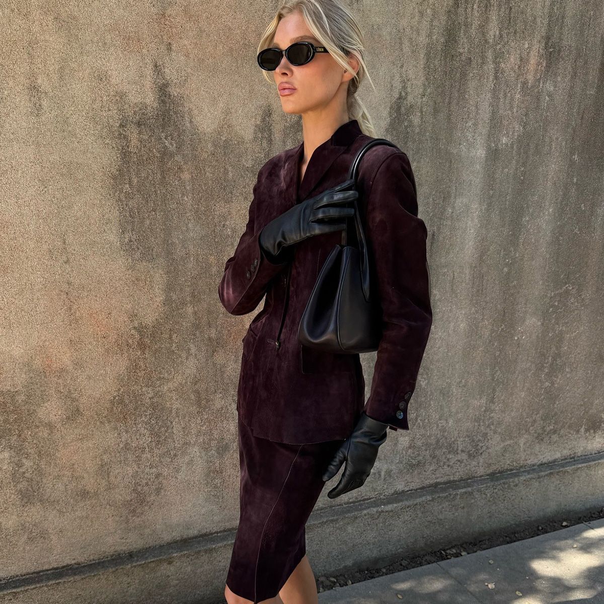 Elsa Hosk wearing a skirt outfit idea for 2026, including a burgundy matching skirt suit.