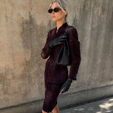 Elsa Hosk wearing a skirt outfit idea for 2026, including a burgundy matching skirt suit.