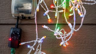 tanglesd fairy lights with multicoloured bulbs next to a timer switch