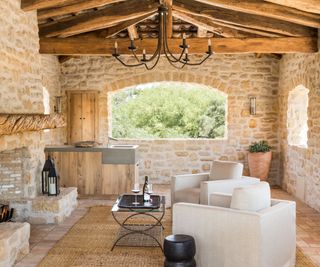 living room with stone walls and fireplace and white furniture