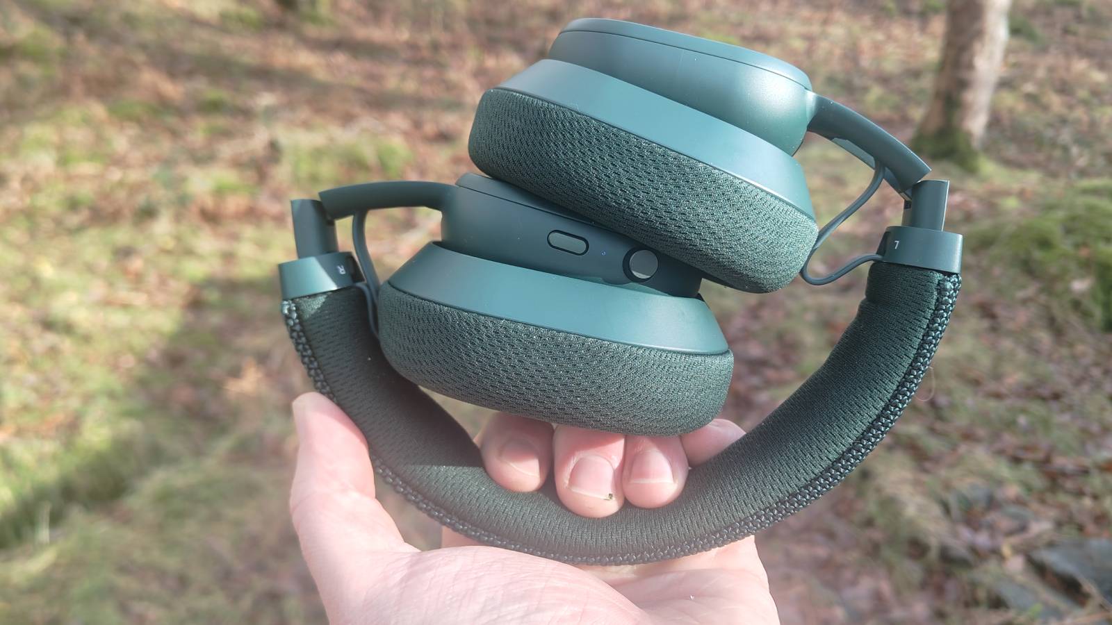 The Fairphone Fairbuds XL 2025 folded down in a man's hand.