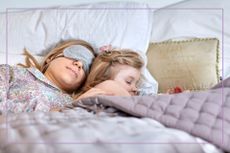 woman asleep with mask on in bed with child