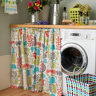 washing machine under the wooden counter covered with curtain