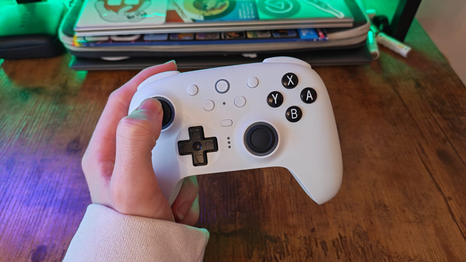 A white 8BitDo Ultimate 2 being held by a reviewer