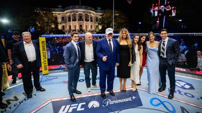 President Donald Trump and his family pose in front of White House in UFC cage