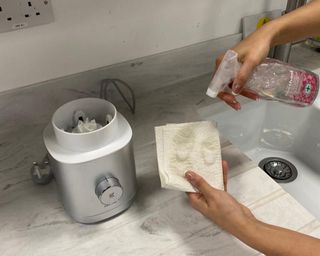 Christina Chrysostomou cleaning the Zwilling personal blender base with paper towel and Method all-purpose anti-bacterial cleaning spray