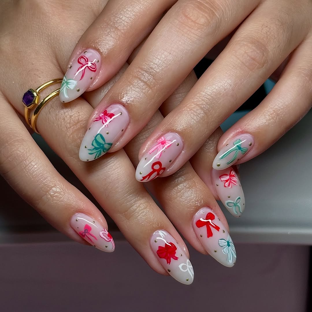 sheer pink, white, red, and green bow holiday nail art