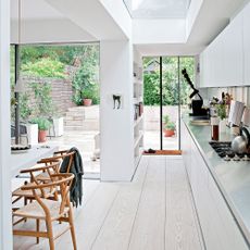 white kitchen with steel worktops and garden beyond