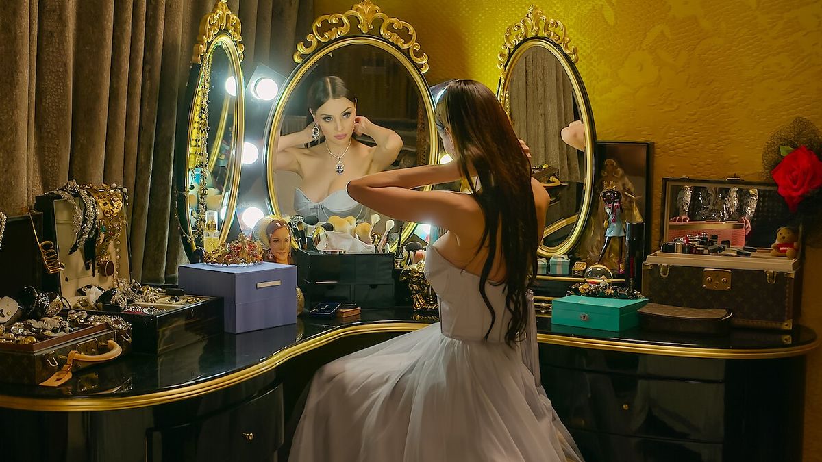 Deborah Hung sitting in front of a mirror putting on jewelry in Bling Empire: New York