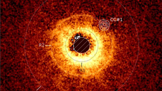 Image of the disk around the star TWA 7 recorded using ESO’s Very Large Telescope’s SPHERE instrument. The image captured with JWST’s MIRI instrument is overlayed. We can clearly see the empty area around TWA 7 B in the R2 ring (CC #1).