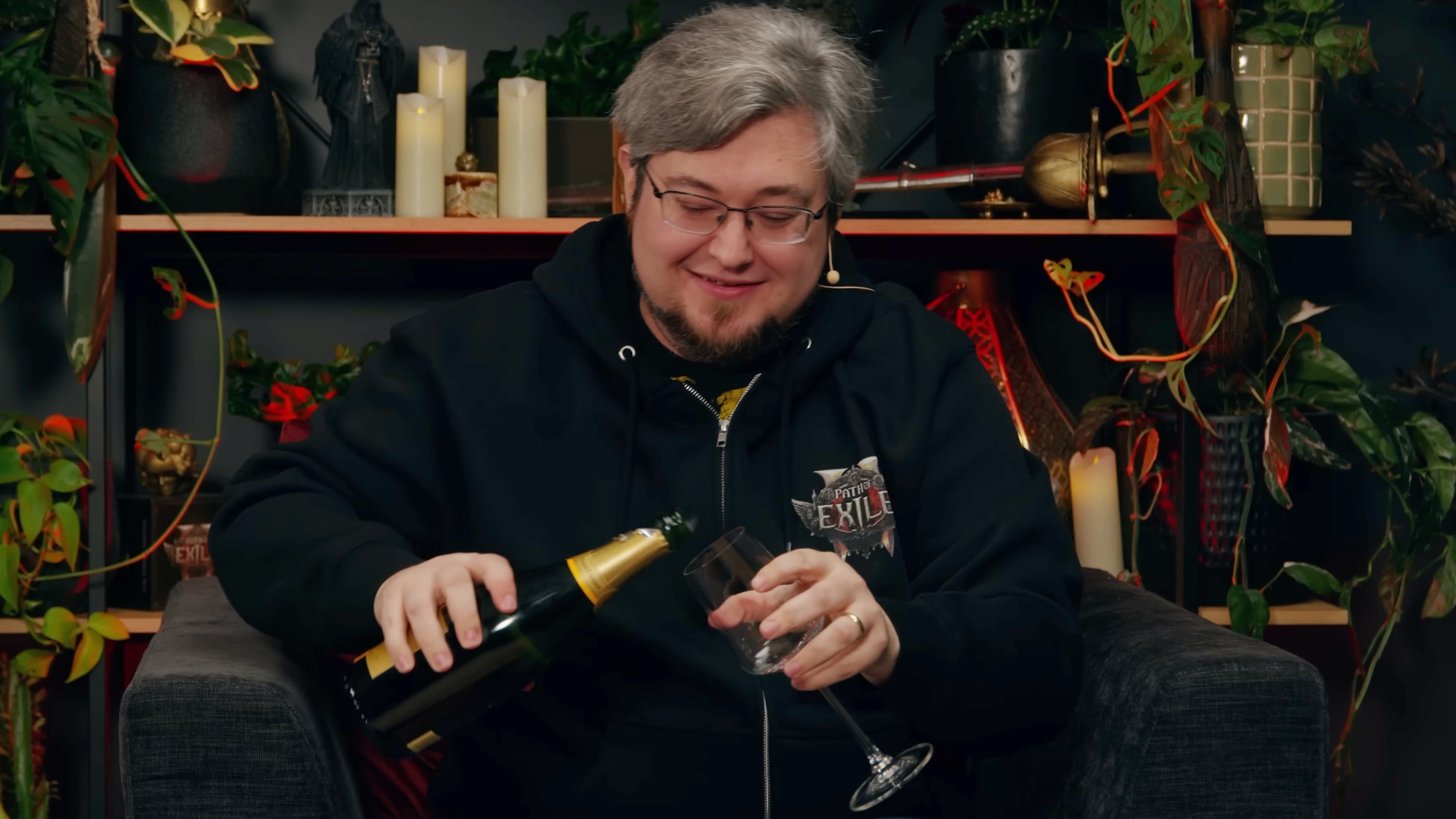 A screencap of a video by Path of Exile 2 developer Grinding Gear Games featuring game director Jonathan Rogers pouring champagne into a glass.