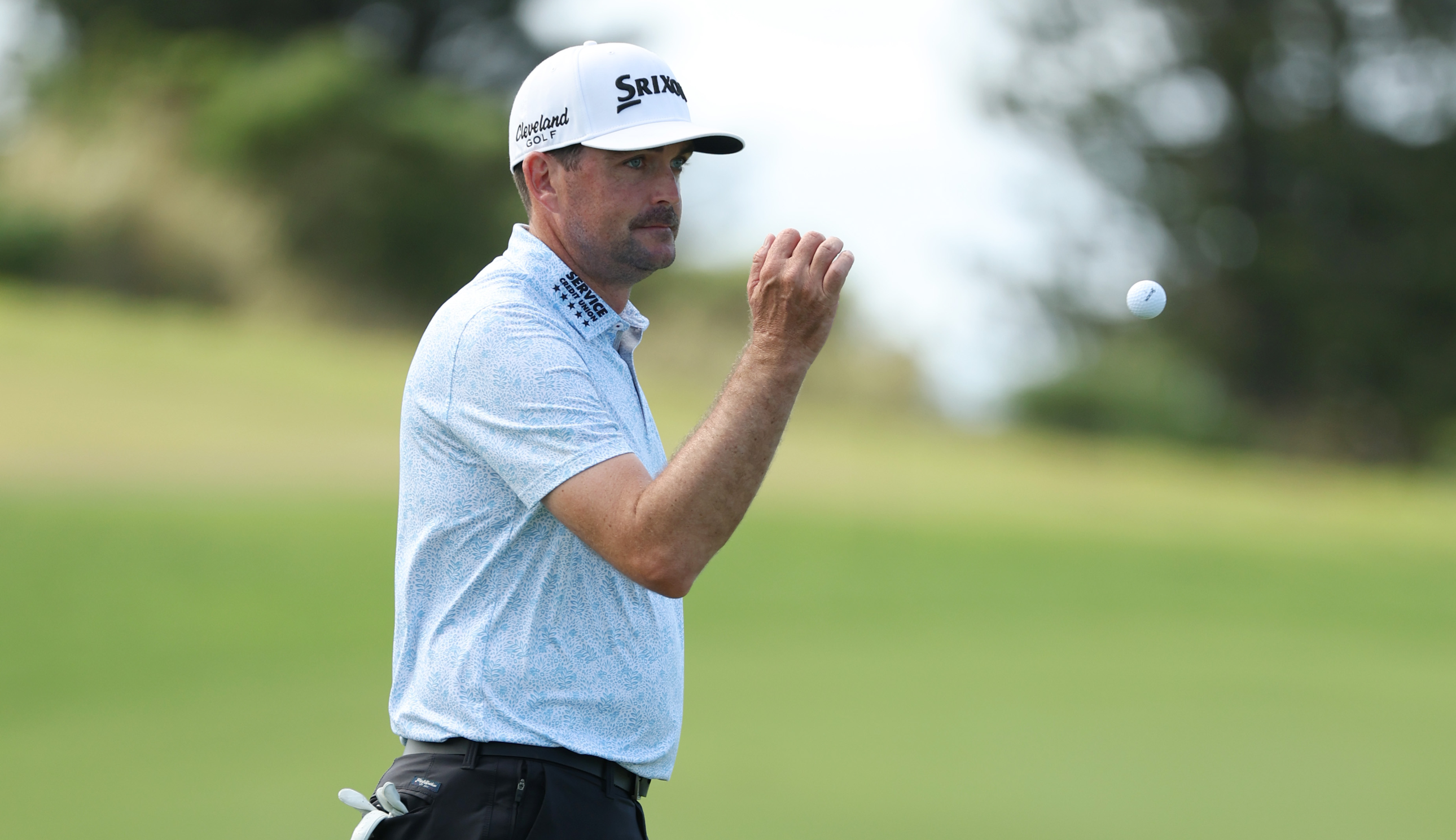 Keegan Bradley throws a golf ball