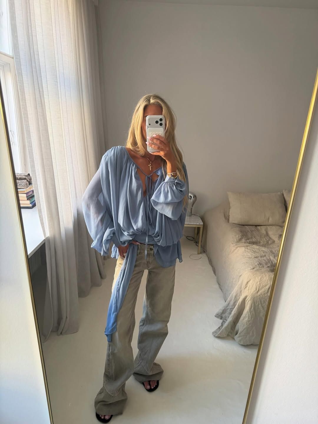 Influencer Emili Sindlev wearing a boho blouse and low-rise jeans.