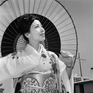 Kyōko Kishida holding an umbrella and wearing traditional japanese robes at cannes