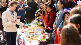 Princess Anne speaks with residents of a street as they hold a Coronation street party