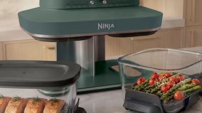 A Green ninja crispi dualzone air fryer with the two glass dishes pulled out.