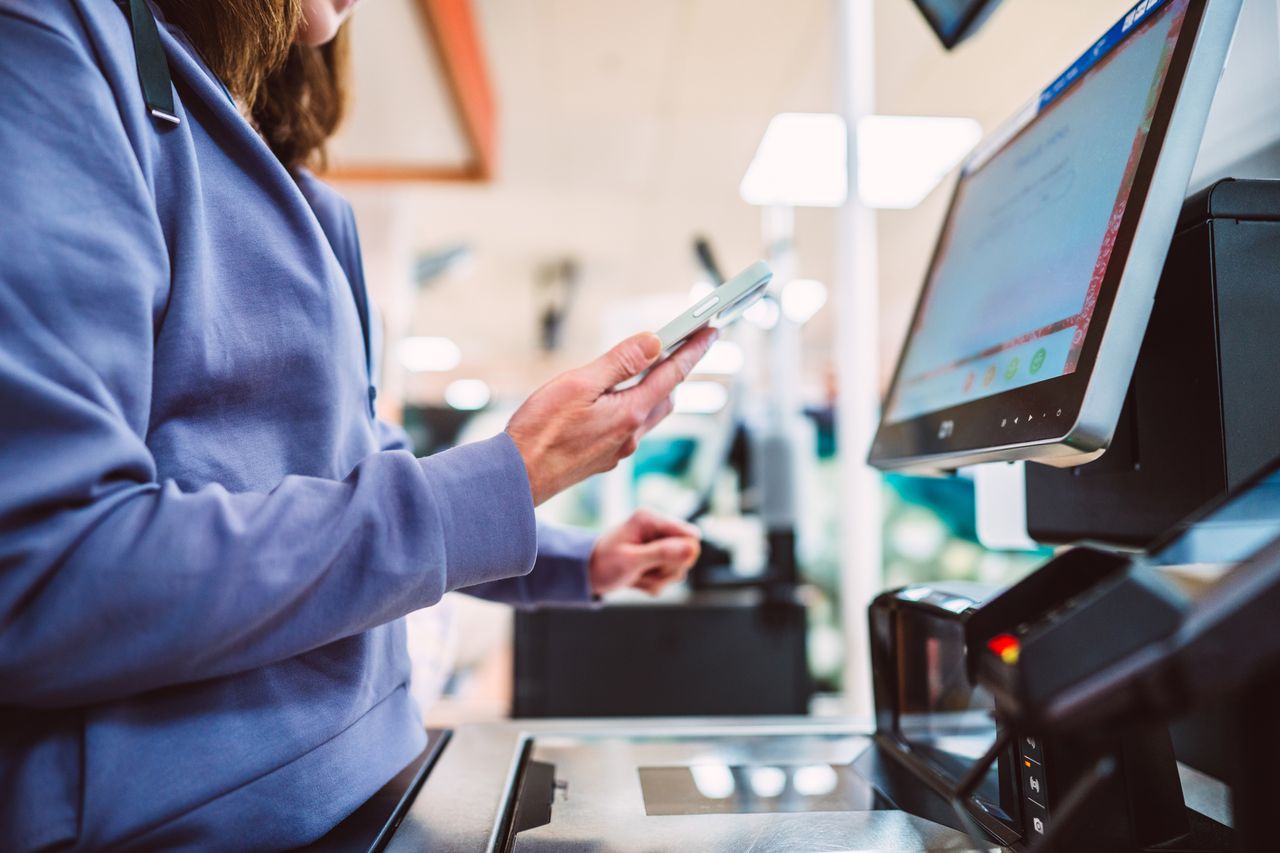 A shopper pays for items in a supermarket as retail price inflation falls