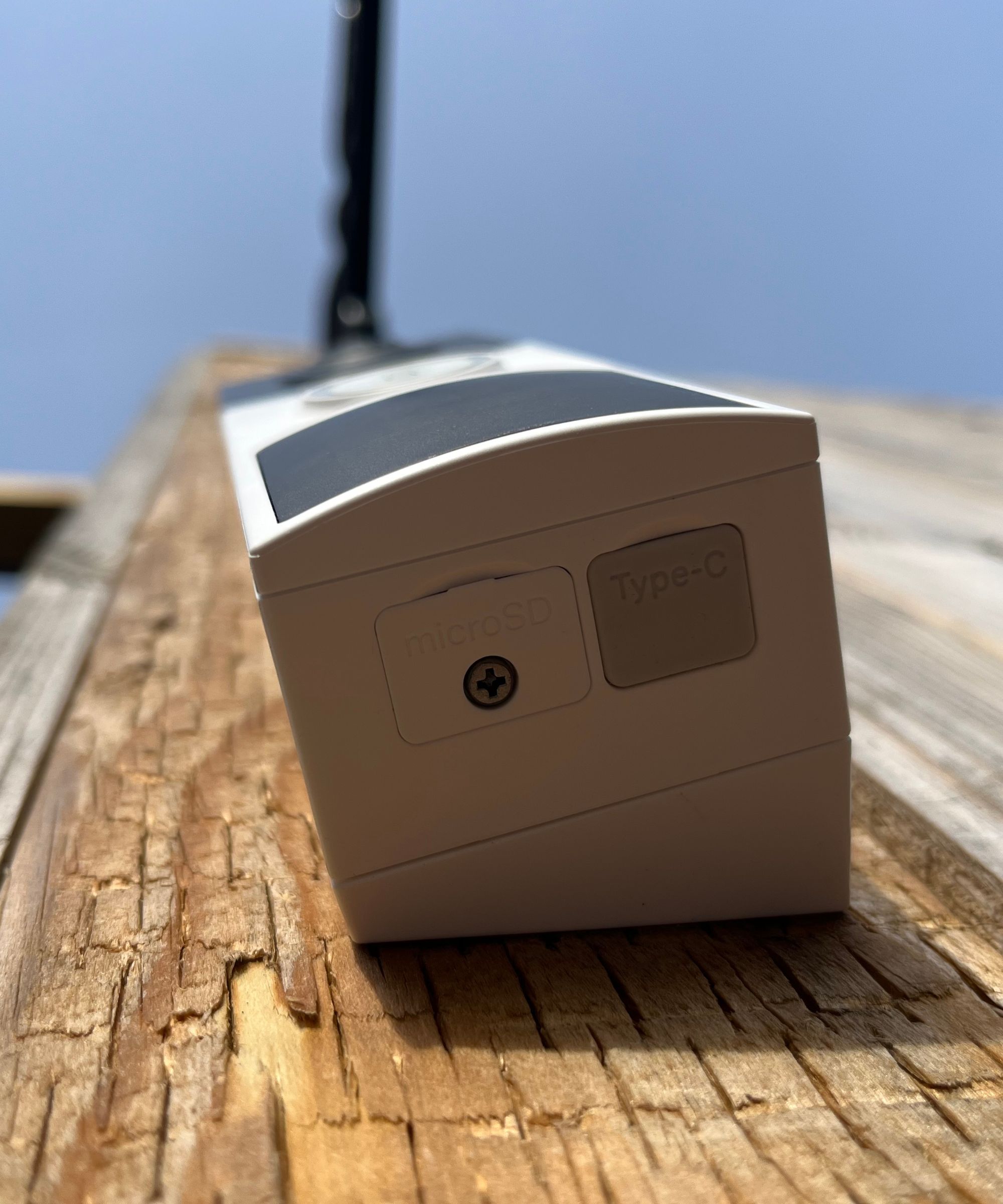 Underside of the Tapo D210 Video Doorbell mounted on wooden surface.