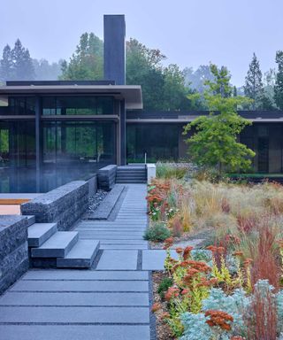 modern backyard with paving, ornamental grasses and pool