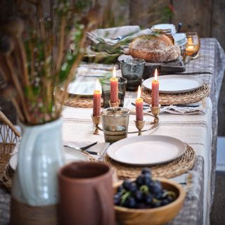 A set dining table with lit candles and tea lights