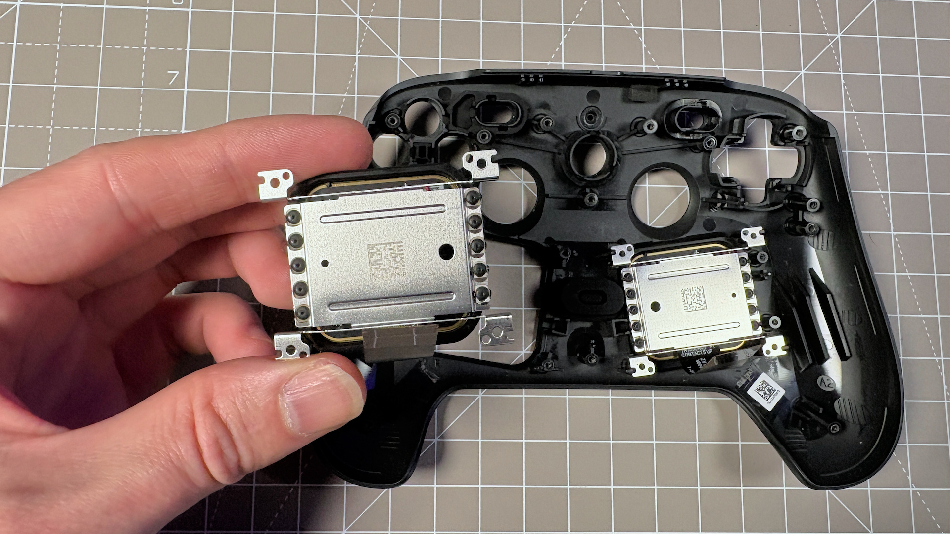 The Steam Controller on a desk during a teardown, with various parts removed.
