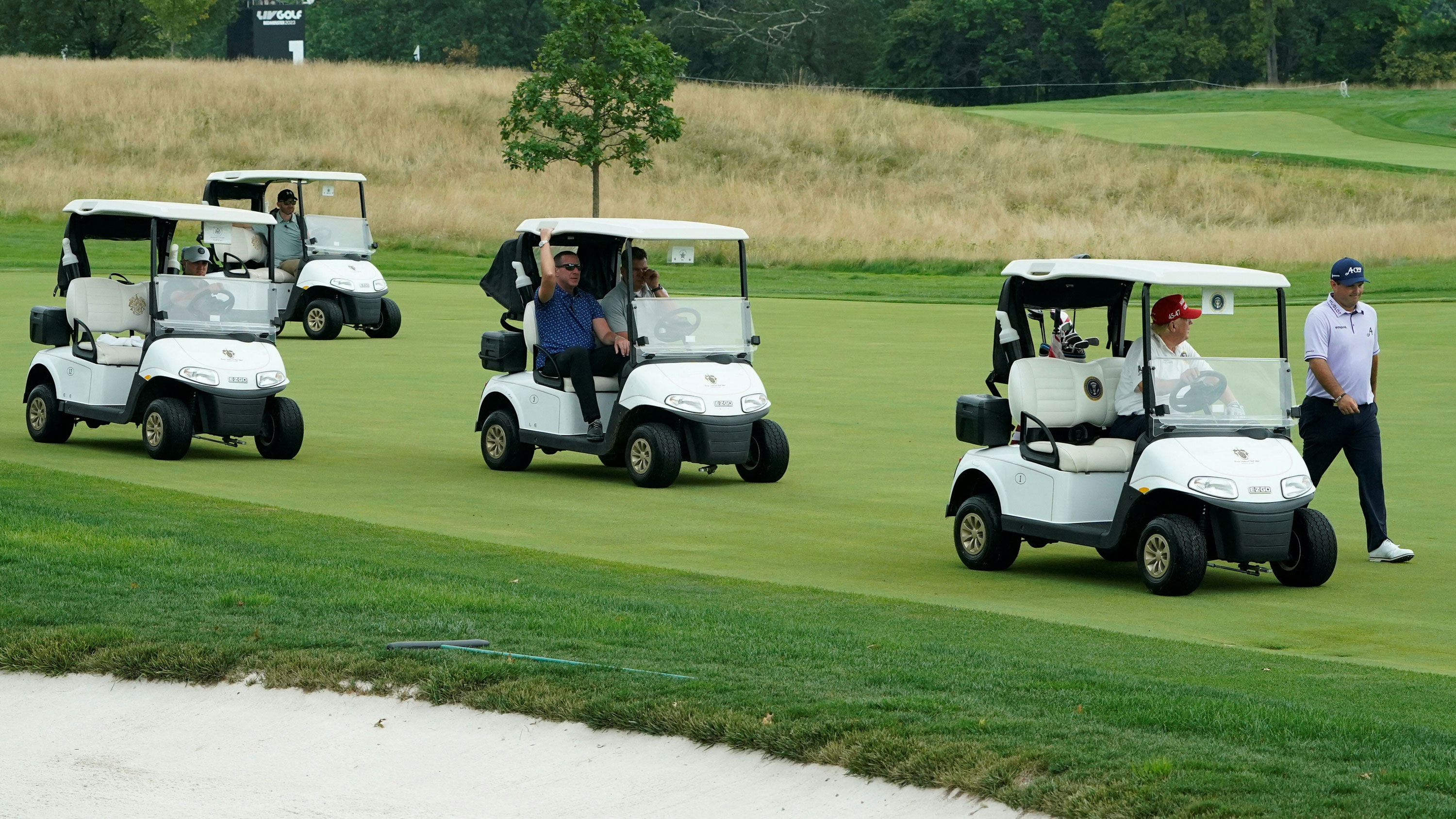 Four golf buggies on a fairway on a golf course