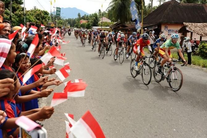 School children cheer on the peloton