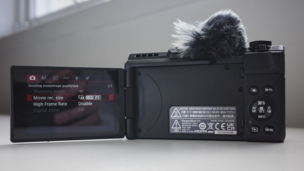 Screen of Canon PowerShot V1 compact vlogging camera open out, on a white desk