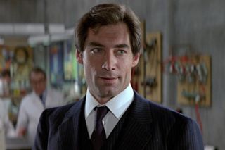 The Living Daylights Timothy Dalton lightly smiling in the Q-Branch lab