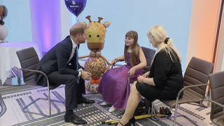 Prince Harry sitting in a chair talking to Scarlett and Aby Cripps at the 2024 WellChild Awards